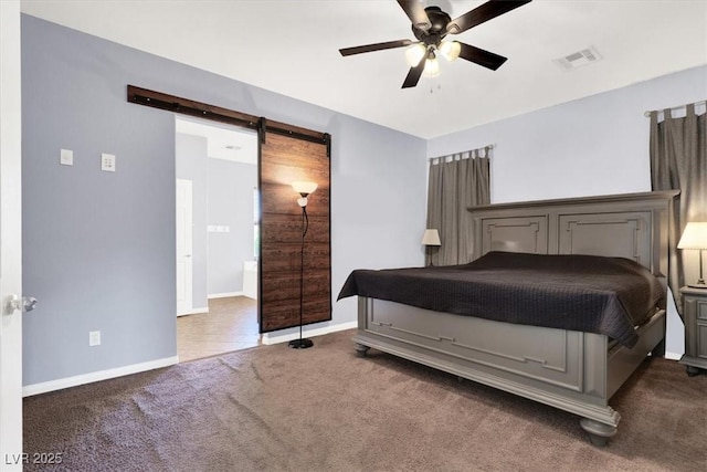 bedroom with visible vents, baseboards, ceiling fan, a barn door, and carpet flooring