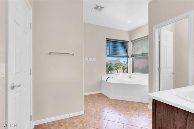 bathroom with visible vents, tile patterned floors, baseboards, a bath, and vanity