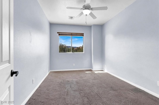 carpeted spare room featuring a ceiling fan, baseboards, and visible vents