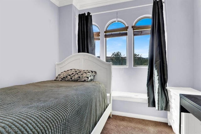 carpeted bedroom featuring baseboards and crown molding