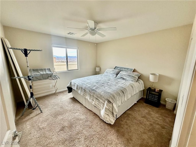 carpeted bedroom featuring visible vents, baseboards, and ceiling fan