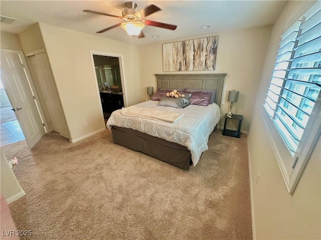 carpeted bedroom featuring a ceiling fan, baseboards, and connected bathroom