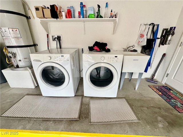 laundry room with laundry area, strapped water heater, and washer and clothes dryer