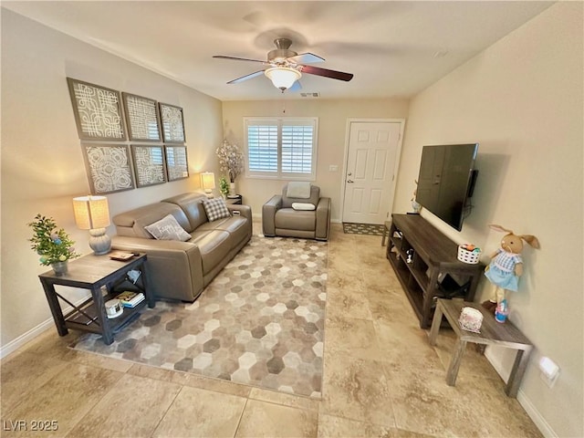 living room with baseboards, visible vents, and ceiling fan