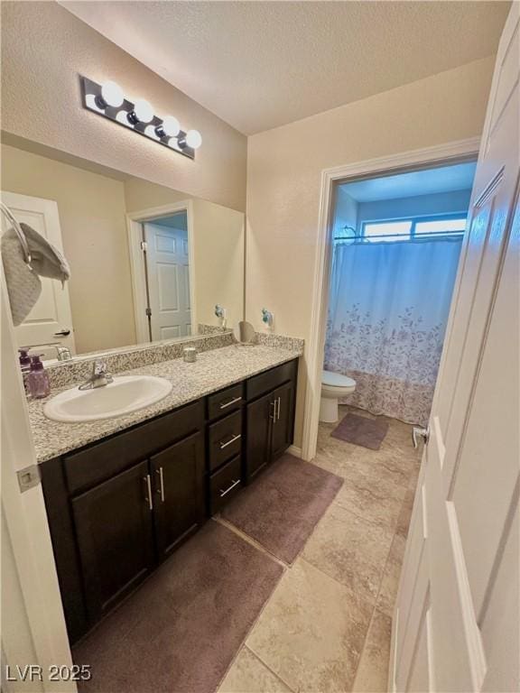 full bathroom featuring a shower with shower curtain, a textured ceiling, toilet, and vanity