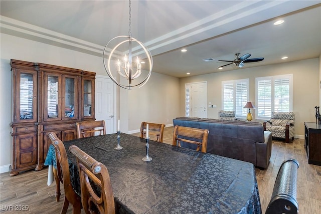 dining space with visible vents, ceiling fan with notable chandelier, recessed lighting, light wood finished floors, and baseboards