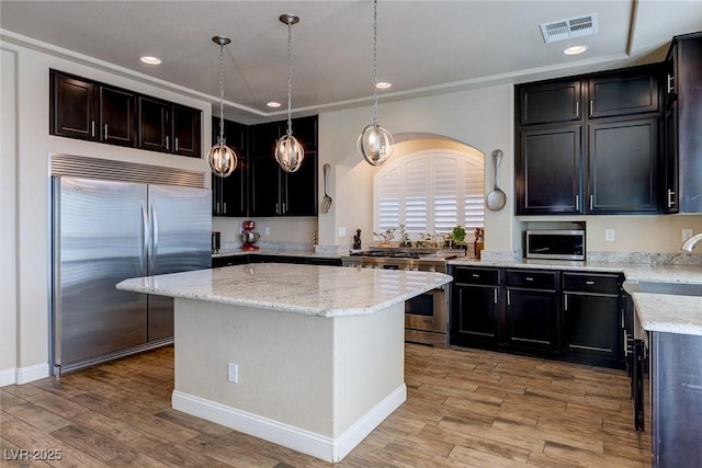 kitchen featuring light stone counters, visible vents, light wood finished floors, recessed lighting, and premium appliances