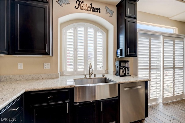 kitchen featuring a sink, wood finished floors, dishwasher, and a wealth of natural light