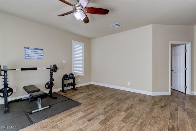 workout room with ceiling fan, visible vents, baseboards, and wood finished floors