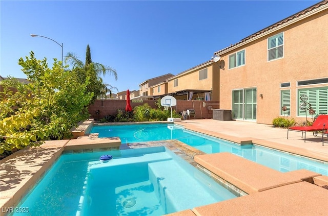 view of swimming pool with a patio, a fenced backyard, and a pool with connected hot tub