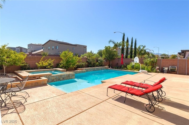 view of pool with a patio, a fenced backyard, and a pool with connected hot tub