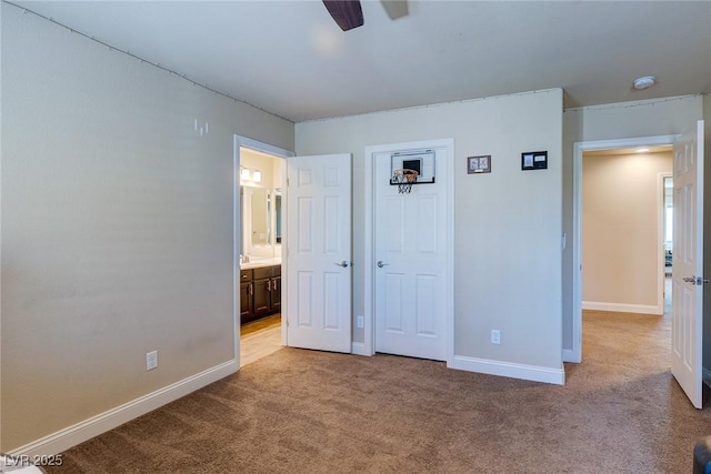 unfurnished bedroom featuring light colored carpet, ensuite bath, and baseboards