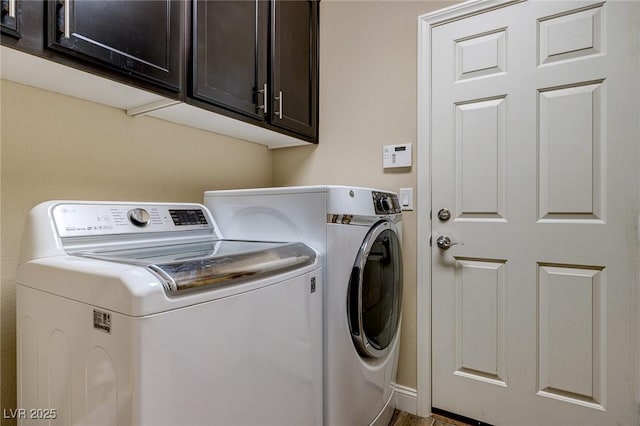 clothes washing area with cabinet space and washer and clothes dryer