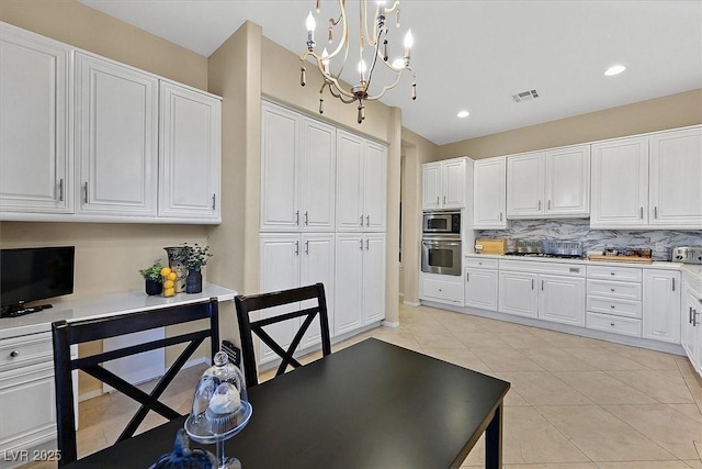 kitchen with visible vents, light tile patterned floors, an inviting chandelier, white cabinets, and stainless steel appliances