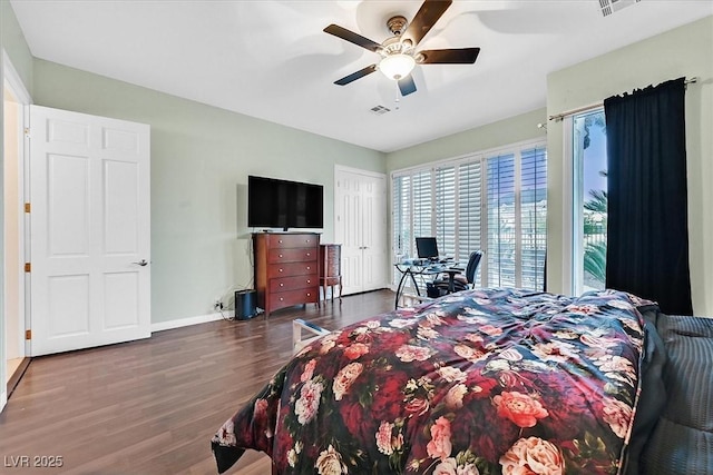 bedroom featuring a ceiling fan, wood finished floors, visible vents, and baseboards