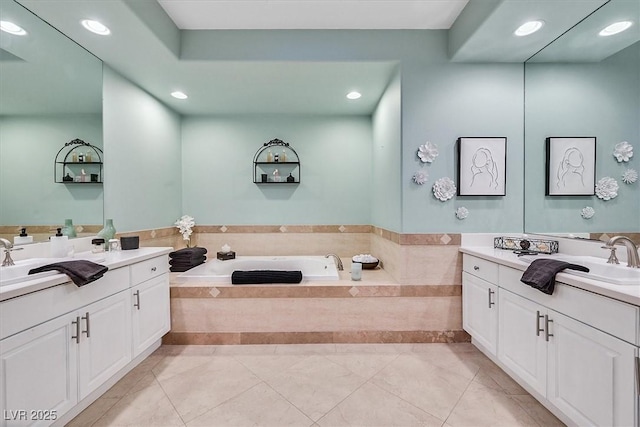 full bathroom featuring a bath, recessed lighting, two vanities, and a sink