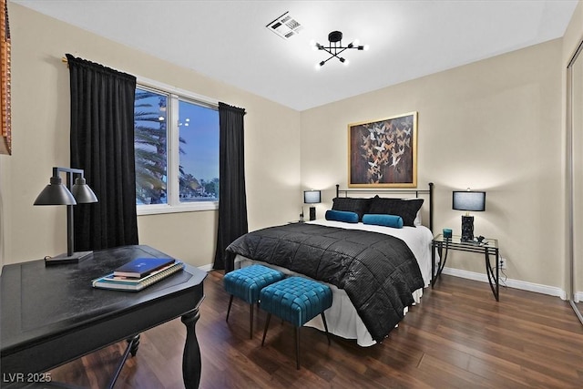 bedroom featuring visible vents, baseboards, and wood finished floors