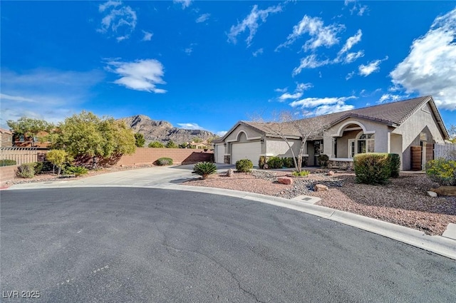 single story home with a garage, concrete driveway, stucco siding, and fence