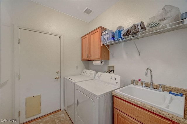 clothes washing area with cabinet space, visible vents, washer and dryer, and a sink