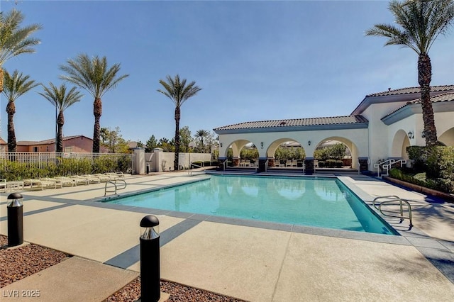 community pool featuring a patio and fence