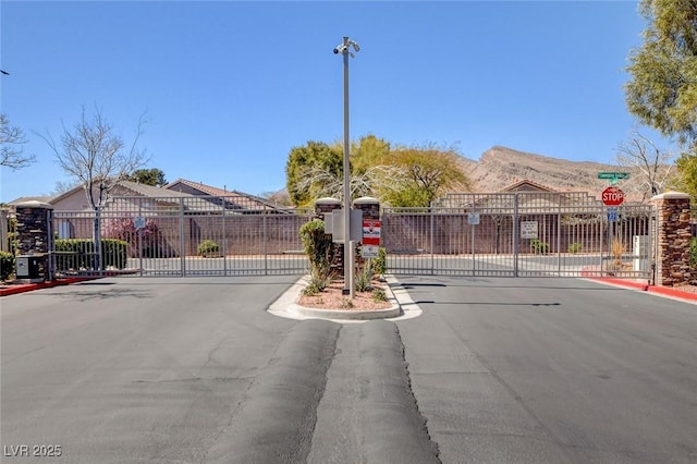 view of street with a gated entry, traffic signs, and a gate