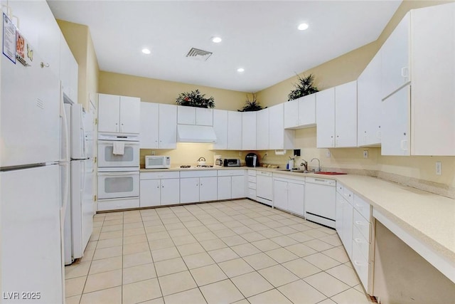 kitchen featuring white appliances, ventilation hood, visible vents, a sink, and light countertops