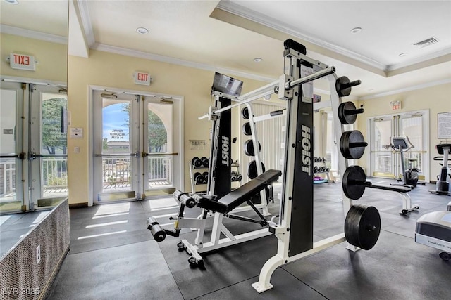 exercise room featuring a tray ceiling, french doors, visible vents, and ornamental molding