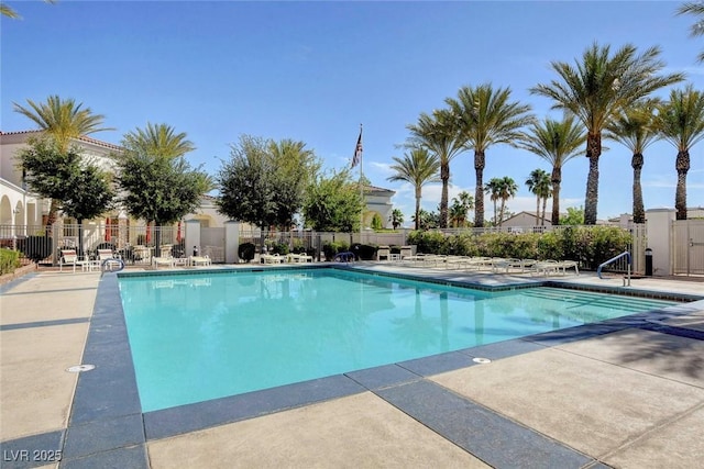 pool with a patio and fence