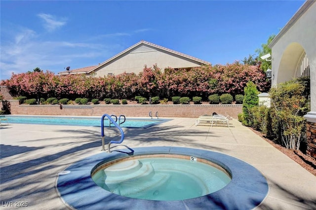 outdoor pool with an in ground hot tub and a patio