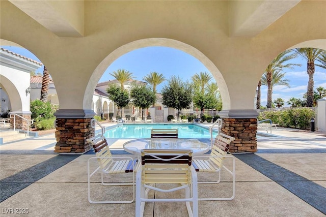 view of patio featuring a community pool and fence