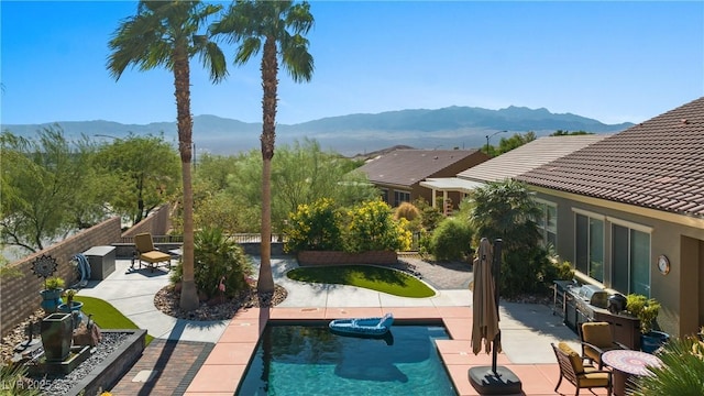 outdoor pool with a mountain view, a patio, and fence