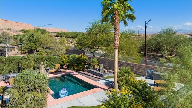 view of swimming pool featuring a mountain view, a fenced in pool, fence private yard, and a patio area