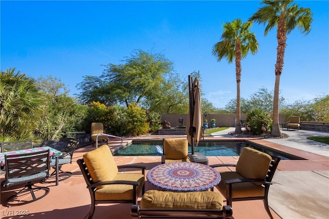 view of patio / terrace featuring outdoor dining space, a fenced in pool, and a fenced backyard