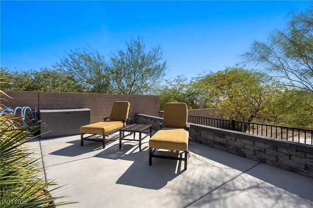 view of patio / terrace featuring a jacuzzi and fence