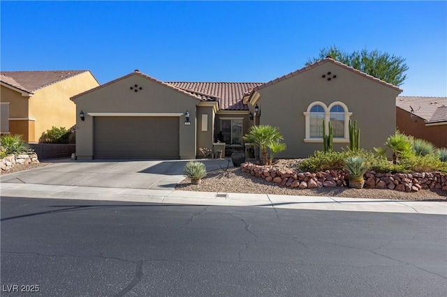 mediterranean / spanish house featuring concrete driveway, an attached garage, a tile roof, and stucco siding