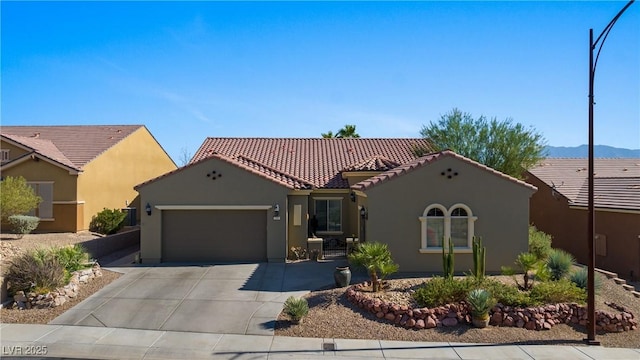 mediterranean / spanish-style house featuring stucco siding, concrete driveway, an attached garage, and a tile roof