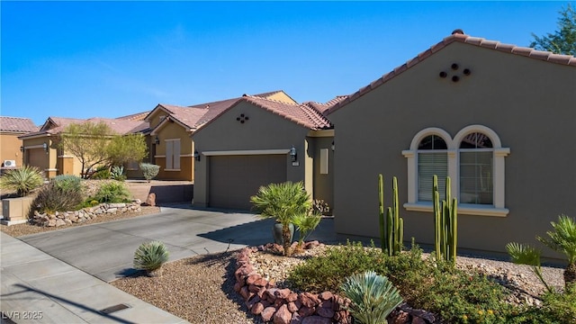 mediterranean / spanish-style home featuring a tile roof, a garage, driveway, and stucco siding