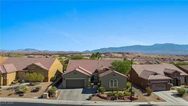 view of front of property with a mountain view, a residential view, and an attached garage