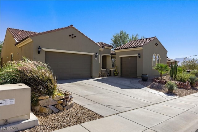 mediterranean / spanish-style home featuring a tile roof, stucco siding, an attached garage, and concrete driveway