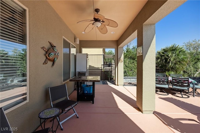 view of patio with outdoor dining space and a ceiling fan