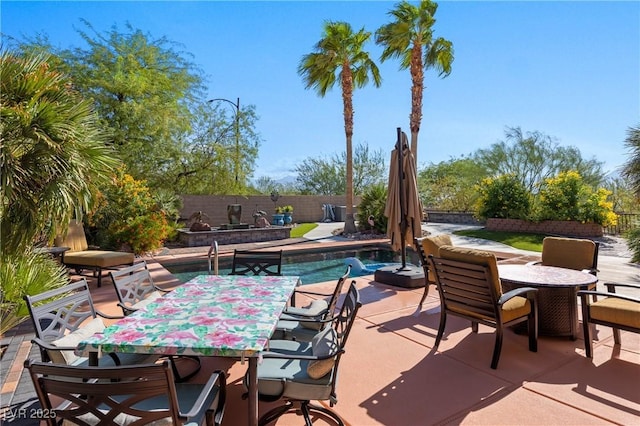 view of patio / terrace with outdoor dining area, a fenced backyard, and a fenced in pool