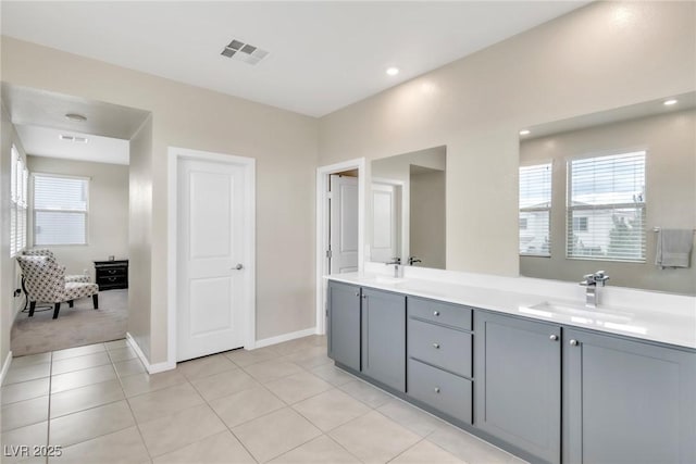 full bathroom featuring visible vents, baseboards, double vanity, tile patterned floors, and a sink