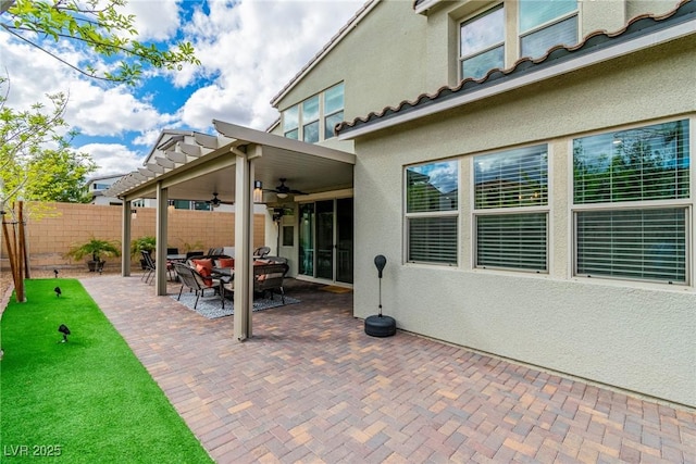 view of patio with a ceiling fan and fence