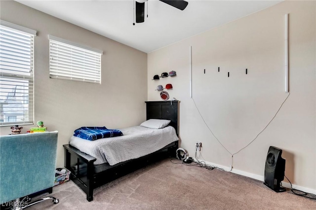 carpeted bedroom with baseboards, multiple windows, and a ceiling fan