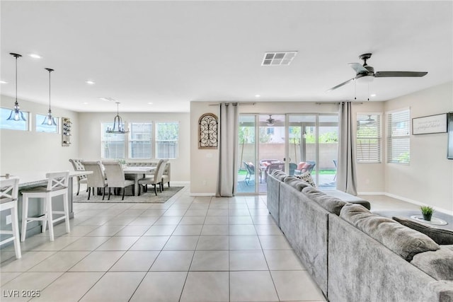 living area featuring light tile patterned flooring, visible vents, a wealth of natural light, and ceiling fan