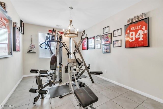 workout room with tile patterned floors, baseboards, and a chandelier