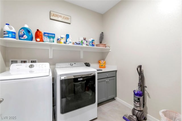 laundry area featuring washer and dryer, baseboards, and cabinet space