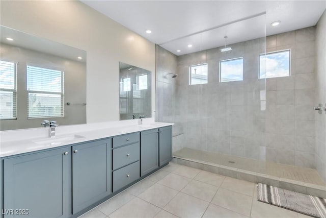 bathroom featuring double vanity, tile patterned floors, a walk in shower, and a sink