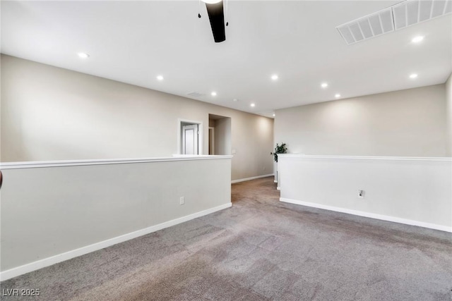 carpeted spare room featuring recessed lighting, visible vents, and baseboards