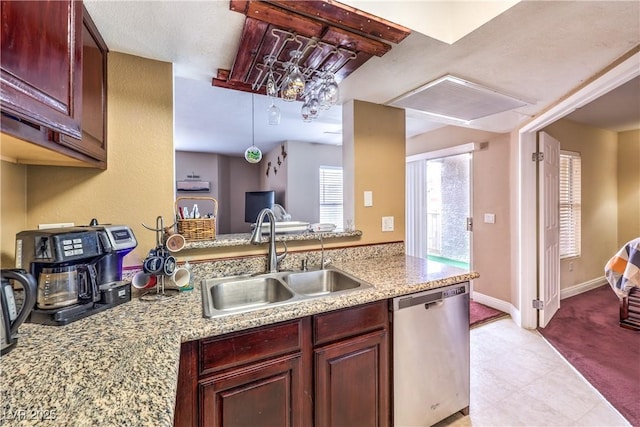 kitchen with dishwasher, baseboards, reddish brown cabinets, and a sink